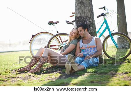 Stock Image - Cycling couple taking a break at Venice Beach, Los Angeles, California, USA. Fotosearch