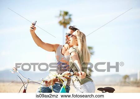 Cycling couple taking a selfie at Venice Beach, Los Angeles, California, USA View Large Photo Image Stock Photo - Cycling couple taking a selfie at Venice Beach, Los Angeles, California, USA. Fotosearch