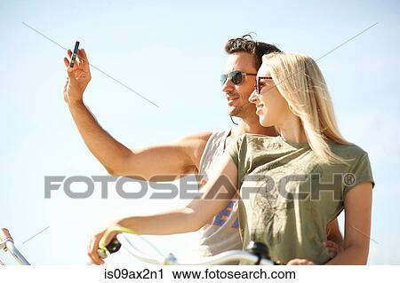 Cycling couple taking smartphone selfie at Venice Beach, Los Angeles, California, USA View Large Photo Image Stock Image - Cycling couple taking smartphone selfie at Venice Beach, Los Angeles, California, USA. Fotosearch