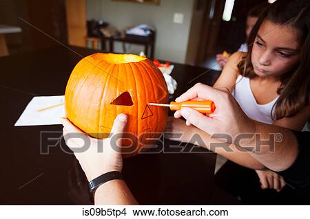 Daughter watching father carve pumpkin View Large Photo Image Picture - Daughter watching father carve pumpkin. Fotosearch