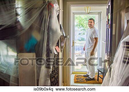 Decorator in entrance hall doorway looking at camera smiling View Large Photo Image Stock Photography - Decorator in entrance hall doorway looking at camera smiling. Fotosearch