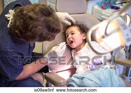 Dentist giving girl in dentist chair dental examination View Large Photo Image Stock Image - Dentist giving girl in dentist chair dental examination. Fotosearch