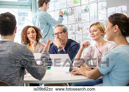 Digital design team discussing at conference table View Large Photo Image Stock Image - Digital design team discussing at conference table. Fotosearch