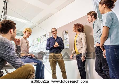 Stock Image - Digital design team talking in office meeting. Fotosearch