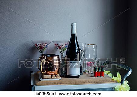 Stock Image - Drinks trolley with wine bottle, glasses and tankards. Fotosearch