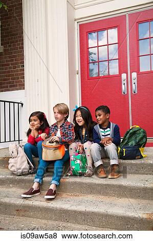 Elementary schoolgirls and boys sitting on elementary school doorway stairs View Large Photo Image Stock Photo - Elementary schoolgirls and boys sitting on elementary school doorway stairs. Fotosearch