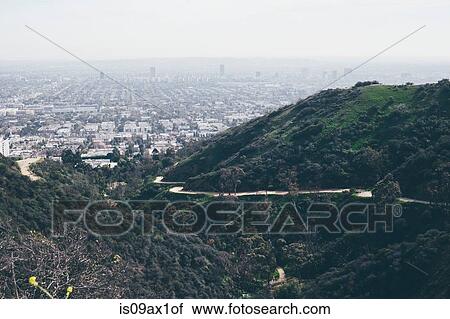 Elevated view of hills and winding road with distant smoggy cityscape, Los Angeles, California, USA View Large Photo Image Stock Image - Elevated view of hills and winding road with distant smoggy cityscape, Los Angeles, California, USA. Fotosearch
