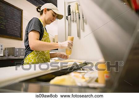 Stock Image - Employee in general store preparing food in kitchen. Fotosearch