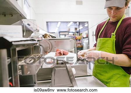 Employee in general store weighing sliced meat in kitchen View Large Photo Image Stock Photo - Employee in general store weighing sliced meat in kitchen. Fotosearch