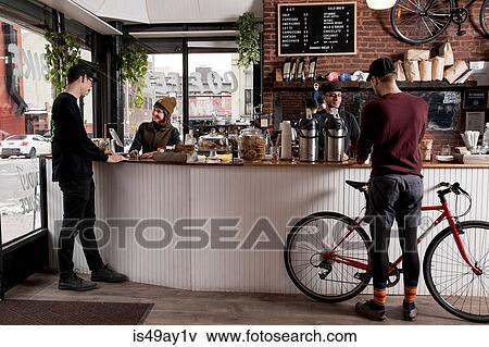 Stock Photo - Employees serving customers in cafe, Nike and Coffee shop, New York, USA. Fotosearch