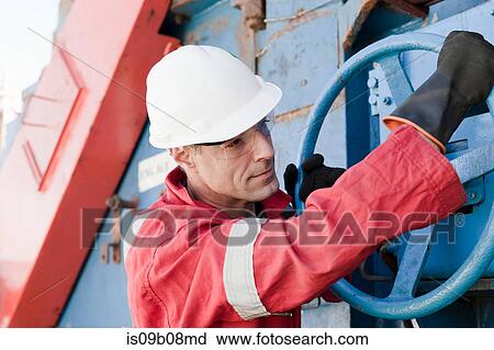 Stock Image - Engineer working on oil rig. Fotosearch