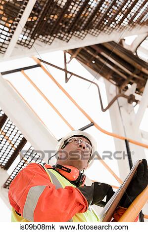 Engineer working on oil rig View Large Photo Image Stock Image - Engineer working on oil rig. Fotosearch