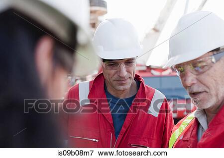 Stock Photo - Engineers in brainstorming session on oil rig. Fotosearch