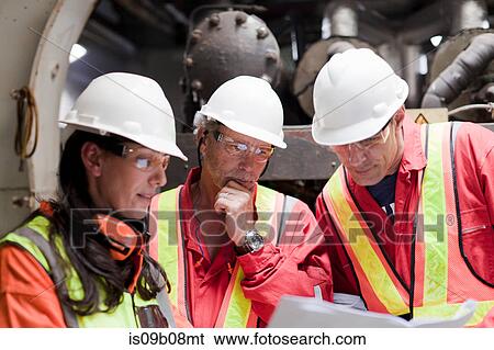 Stock Photograph - Engineers in brainstorming session on oil rig. Fotosearch