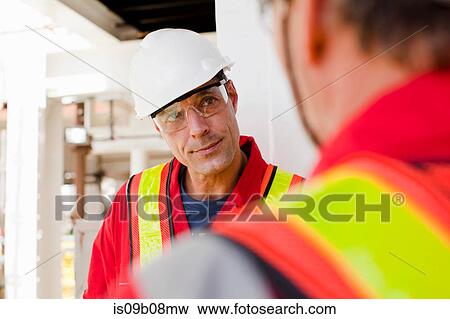 Stock Photo - Engineers in discussion on oil rig. Fotosearch