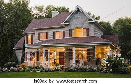 Exterior of illuminated cottage style beige stone, red trimmed home with garden View Large Photo Image Stock Photo - Exterior of illuminated cottage style beige stone, red trimmed home with garden. Fotosearch