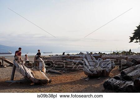 Family sitting on wood sculpture on beach, Vancouver, British Columbia, Canada View Large Photo Image Stock Image - Family sitting on wood sculpture on beach, Vancouver, British Columbia, Canada. Fotosearch