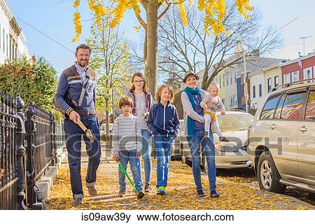 Stock Photo - Family walking along street together. Fotosearch