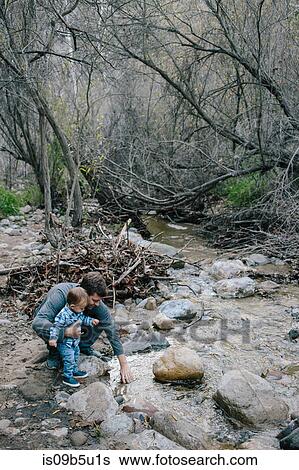 Stock Photograph - Father and baby boy investigating river, Venice Beach, Los Angeles, California, USA. Fotosearch