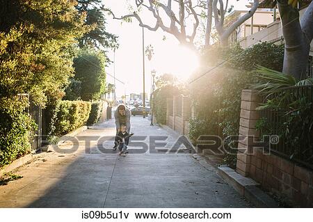 Stock Photo - Father and baby boy walking in residential street, Venice Beach, Los Angeles, California, USA. Fotosearch