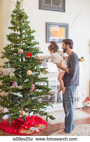 Father and daughter decorating Christmas tree View Large Photo Image Stock Photo - Father and daughter decorating Christmas tree. Fotosearch