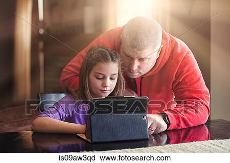 Father and daughter using wireless digital tablet at home View Large Photo Image Stock Image - Father and daughter using wireless digital tablet at home. Fotosearch