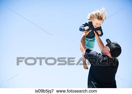 Father and son fooling around outdoors, father lifting son in air View Large Photo Image Stock Photo - Father and son fooling around outdoors, father lifting son in air. Fotosearch
