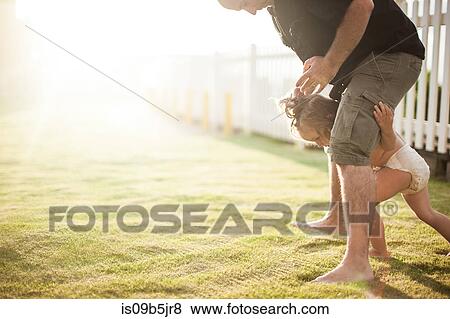 Father and son fooling around outdoors, young boy walking between father's legs View Large Photo Image Stock Photo - Father and son fooling around outdoors, young boy walking between father's legs. Fotosearch