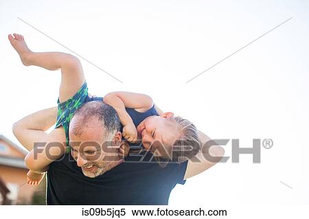 Stock Photography - Father and son fooling around, outdoors, father carrying son over shoulders. Fotosearch