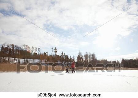 Father and two sons, walking through snow covered landscape View Large Photo Image Picture - Father and two sons, walking through snow covered landscape. Fotosearch