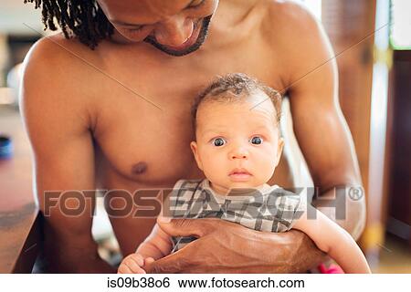 Stock Photograph - Father carrying baby in arms. Fotosearch