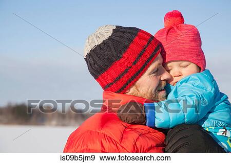 Father carrying young son in snow covered landscape View Large Photo Image Stock Photo - Father carrying young son in snow covered landscape. Fotosearch
