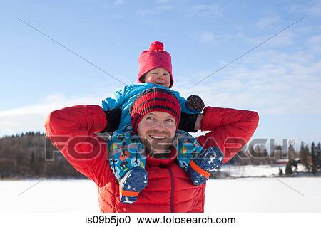 Father carrying young son on shoulders, in snow covered landscape View Large Photo Image Stock Image - Father carrying young son on shoulders, in snow covered landscape. Fotosearch