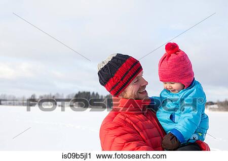 Father holding young son, in snow covered landscape View Large Photo Image Stock Image - Father holding young son, in snow covered landscape. Fotosearch