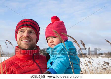 Stock Photo - Father holding young son in snow covered landscape. Fotosearch