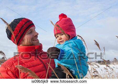 Father holding young son in snow covered landscape View Large Photo Image Stock Photo - Father holding young son in snow covered landscape. Fotosearch