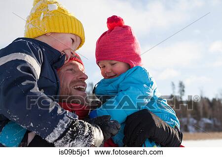 Father holding young sons, smiling, in winter setting View Large Photo Image Stock Image - Father holding young sons, smiling, in winter setting. Fotosearch