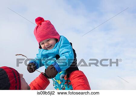 Father lifting young son in air, in snow covered landscape View Large Photo Image Stock Image - Father lifting young son in air, in snow covered landscape. Fotosearch