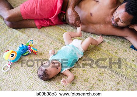 Father playing with baby on bed View Large Photo Image Stock Image - Father playing with baby on bed. Fotosearch