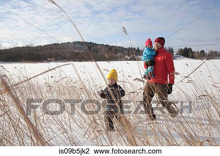 Father walking with two sons in snow covered landscape View Large Photo Image Stock Image - Father walking with two sons in snow covered landscape. Fotosearch