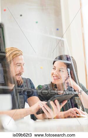 Stock Image - Female and male designers having discussion in creative studio. Fotosearch