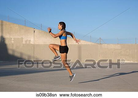 Female athlete doing high knees exercise, Van Nuys, California, USA View Large Photo Image Picture - Female athlete doing high knees exercise, Van Nuys, California, USA. Fotosearch