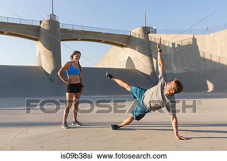 Female athlete observing friend workout, Van Nuys, California, USA View Large Photo Image Stock Image - Female athlete observing friend workout, Van Nuys, California, USA. Fotosearch