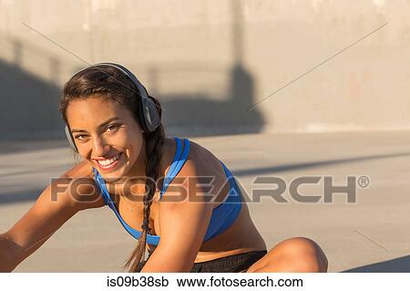 Female athlete with headphones, stretching, Van Nuys, California, USA View Large Photo Image Stock Image - Female athlete with headphones, stretching, Van Nuys, California, USA. Fotosearch