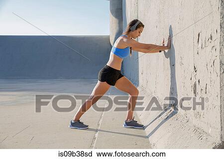 Female athlete with headphones, stretching View Large Photo Image Stock Image - Female athlete with headphones, stretching. Fotosearch