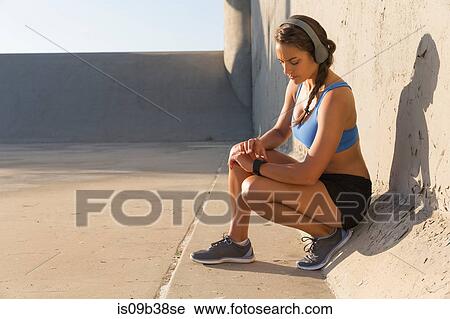 Female athlete with headphones, checking smartwatch View Large Photo Image Stock Image - Female athlete with headphones, checking smartwatch. Fotosearch