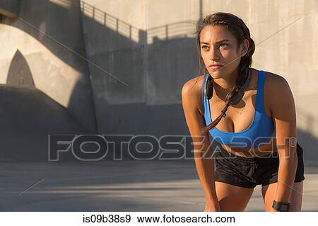 Female athlete with headphones, stretching, Van Nuys, California, USA View Large Photo Image Stock Photo - Female athlete with headphones, stretching, Van Nuys, California, USA. Fotosearch