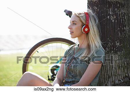 Female cyclist sitting listening to headphone music at Venice Beach, Los Angeles, California, USA View Large Photo Image Stock Image - Female cyclist sitting listening to headphone music at Venice Beach, Los Angeles, California, USA. Fotosearch