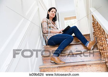 Stock Photograph - Female designer contemplating on creative studio stairway. Fotosearch