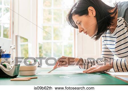 Female designer cutting paper with scalpel in creative studio View Large Photo Image Stock Image - Female designer cutting paper with scalpel in creative studio. Fotosearch